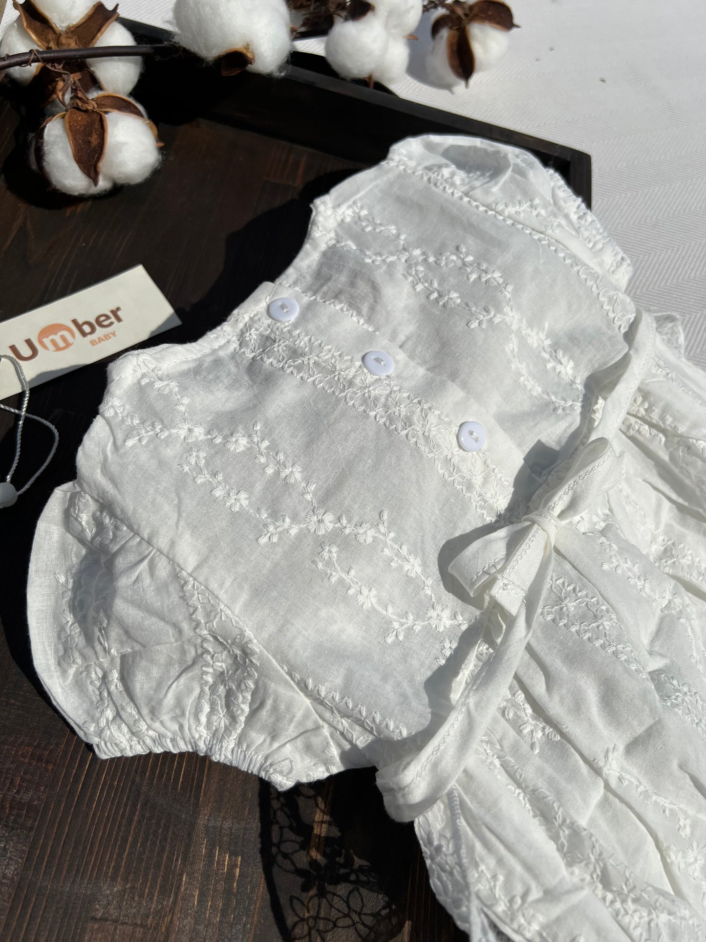 Back of White Baby Romper with Embroidered Flower Pattern and Button-up Back Detail