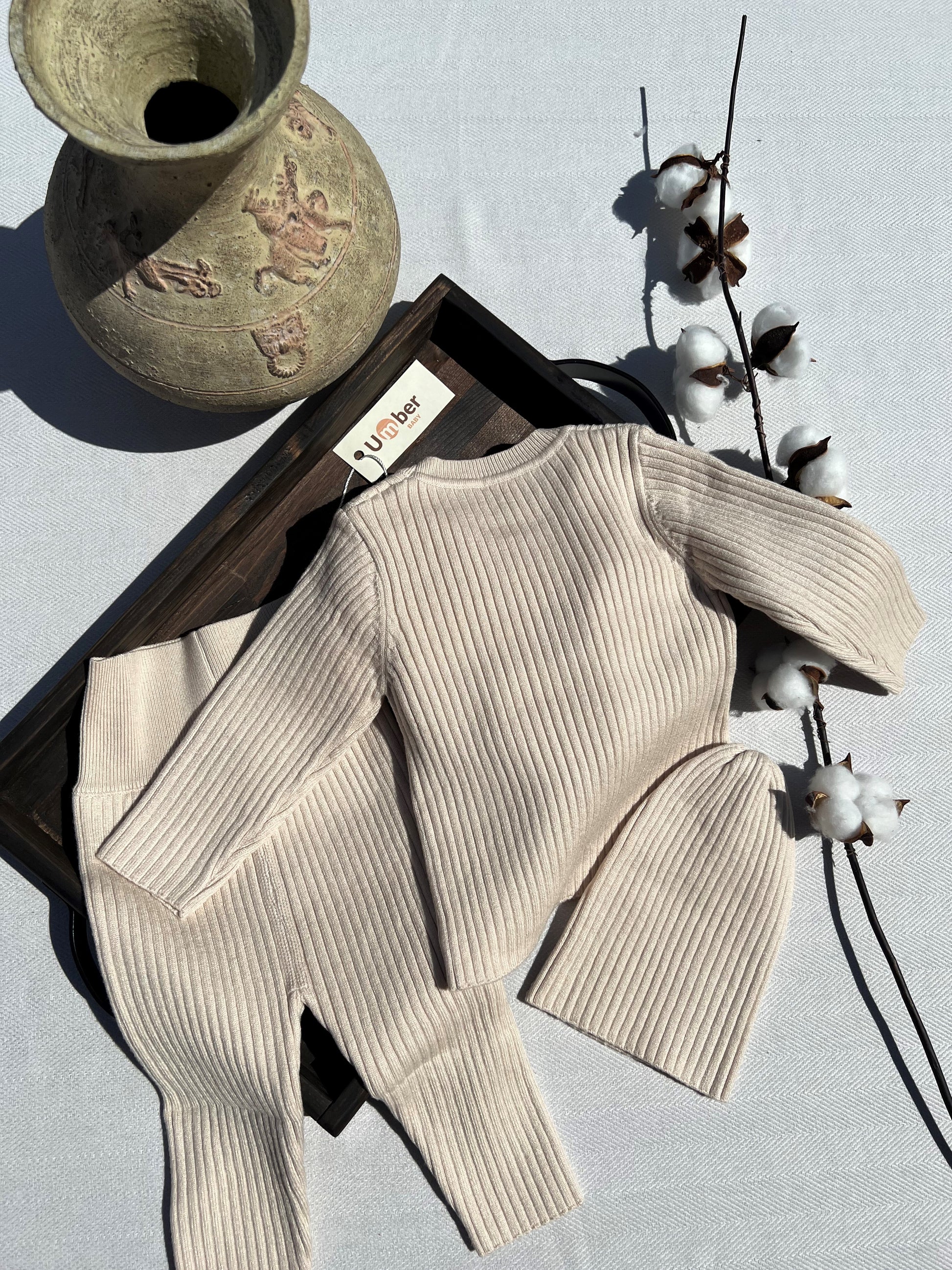 Back of Beige Three Piece Baby Lounge Set with Long Sleeve Ribbed Shirt, Pants and Hat