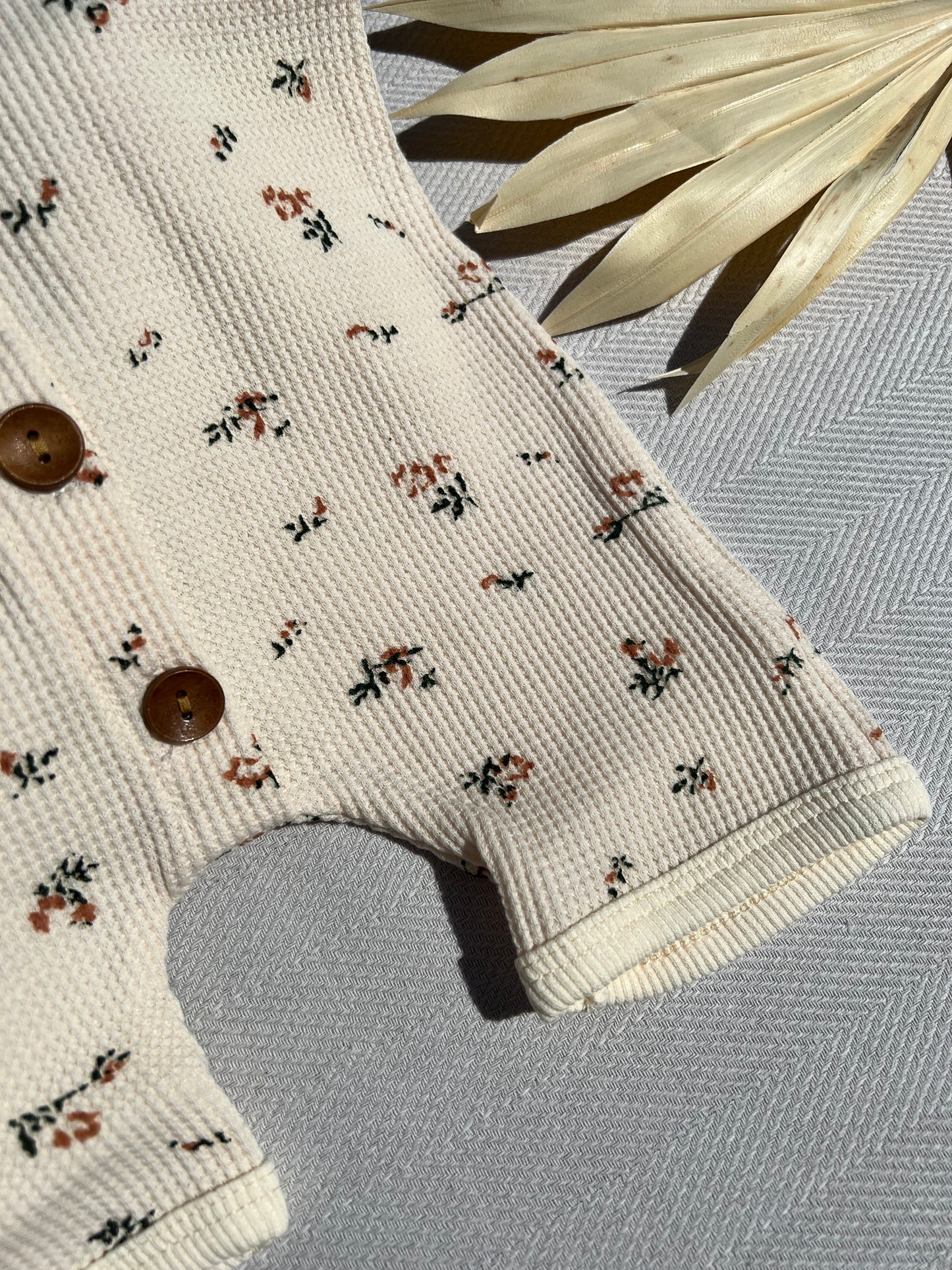Beige Short Sleeve Waffle Baby Romper with Small Pink Flower Pattern and Brown Buttons